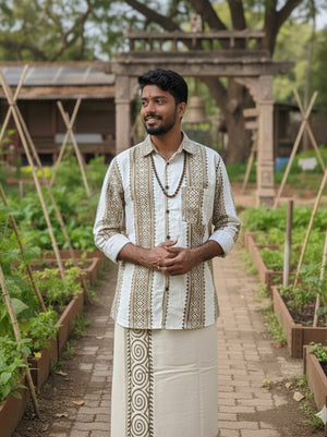 A man stands smiling in a garden with raised beds, wooden supports for plants, and a rustic archway in the background, wearing the Dwara Shirt—a cream and brown block print cotton shirt styled in traditional Indian fashion.