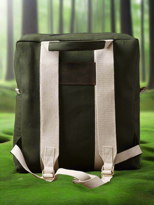 The Kelly Back Pack, featuring a vibrant green color and contrasting white straps, rests on a matching green surface against a softly blurred forest background—making it a stylish choice for your next adventure.