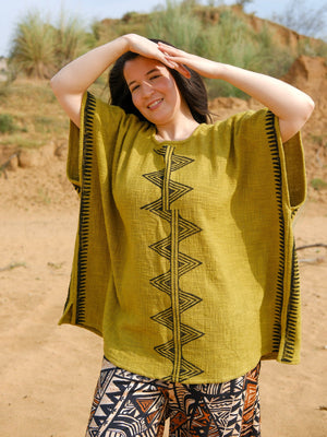 Mustard-olive hand printed cotton poncho, front view on model