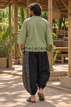 Back view of green baggy kurta showing printed hem border above black dhoti pants
