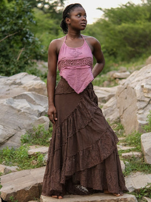 Brown gypsy wrap skirt full length on a model standing on rocks, hand on hip and ruffled lace tiers spreading