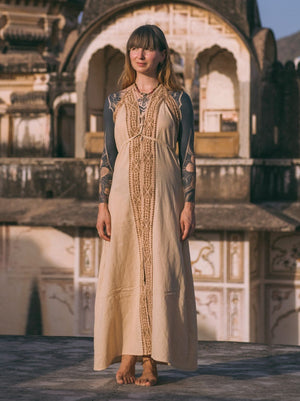 Beige Devi Maxi Dress with hand block print border, front view at desert ruin, full length