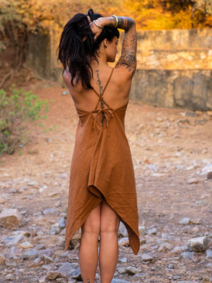 Back view of the Dumati Dress showing the open back, crossed halter straps and tie bow above the draped handkerchief hem