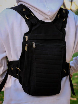 Black canvas Enigma Ninja Bag worn on the chest, buckled waist belt and side zip in view over a hoodie