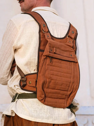 Model in a cream linen shirt wearing the rust brown Enigma Ninja Bag on his back against a white wall
