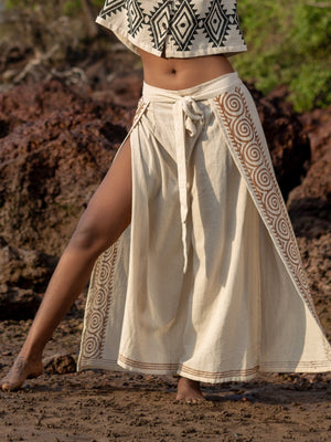 Fisherman wrap pants in natural cotton, full body front view with side slit on beach