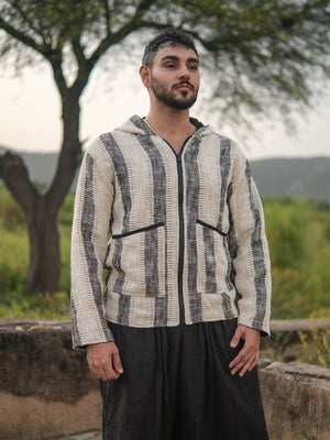 Three-quarter view of the striped cotton hooded jacket, model looking away, textured open weave in daylight