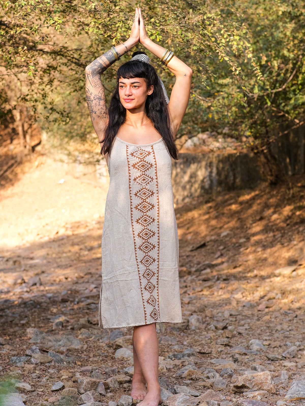 Model wearing the Lina Dress with arms raised, showing the free size A-line fall of the beige block print cotton dress