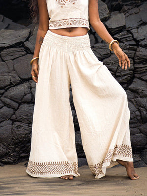 Natural cotton Medusa palazzo pants with brown block print hem border, worn with an embroidered ivory crop top