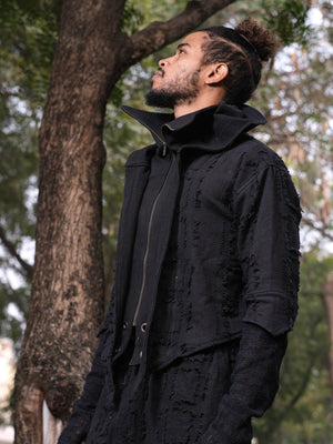 Side profile of a man in the black ninja hoodie with the stand collar open and the front zip running down the chest