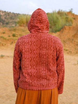 Rear view of the Rangrek unisex hooded jacket in rust handblock print cotton, cropped hem and full sleeves