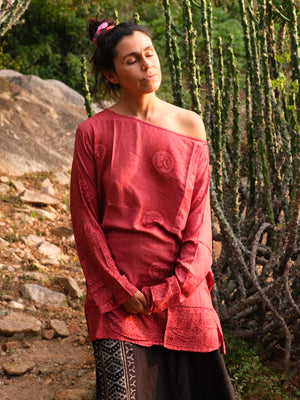 Red Om print viscose kurta worn off one shoulder, long printed sleeves falling past the wrist