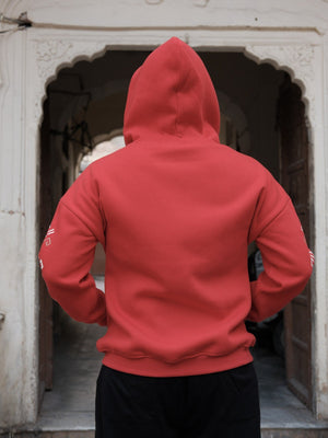 Back view of the Riwaayat red hoodie with hood up and geometric sleeve detail, plain rear panel