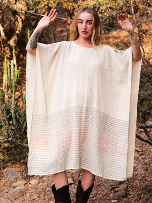 Free-size cream cotton Yaja Kaftan with script print, styled with black cowboy boots in the desert