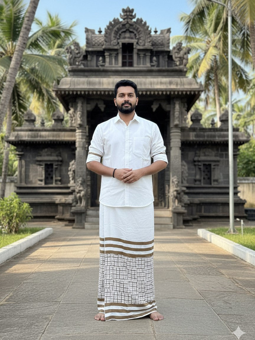 A man wearing the Swarna Chitra Dhoti and a white shirt stands barefoot on a path, with a stone temple and palm trees in the background.