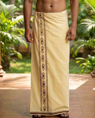 A man stands outdoors wearing the Mehfil Dhoti in lemon yellow, featuring his upper body exposed. The traditional attire brings an ethnic touch to the scene, set against lush green plants and a tiled floor in the background.
