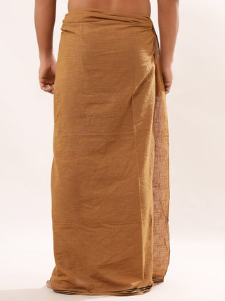 A person wearing a Tribal Dhoti in traditional Indian style stands against a plain white background. The brown dhoti features Rajasthani hand block-print, wrapping around the waist and flowing to the ankles, embodying timeless elegance and cultural heritage.