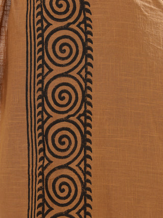 A close-up of the Tribal Dhoti textile showcases a brown backdrop with a vertical black design, inspired by traditional Indian style. Featuring spirals, vertical lines, and leaf-like shapes, it reflects the elaborate artistry of Rajasthani hand block-print techniques.