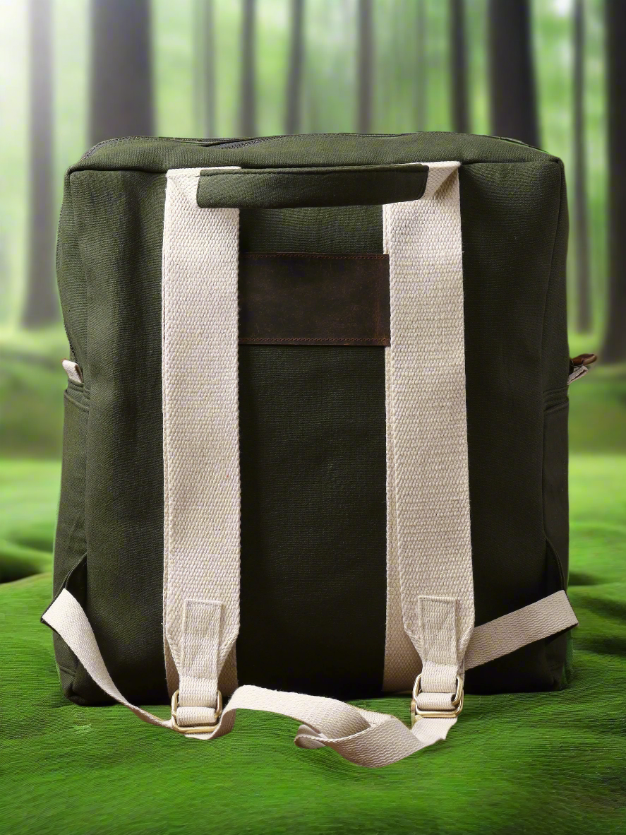 The Kelly Back Pack, featuring a vibrant green color and contrasting white straps, rests on a matching green surface against a softly blurred forest background—making it a stylish choice for your next adventure.
