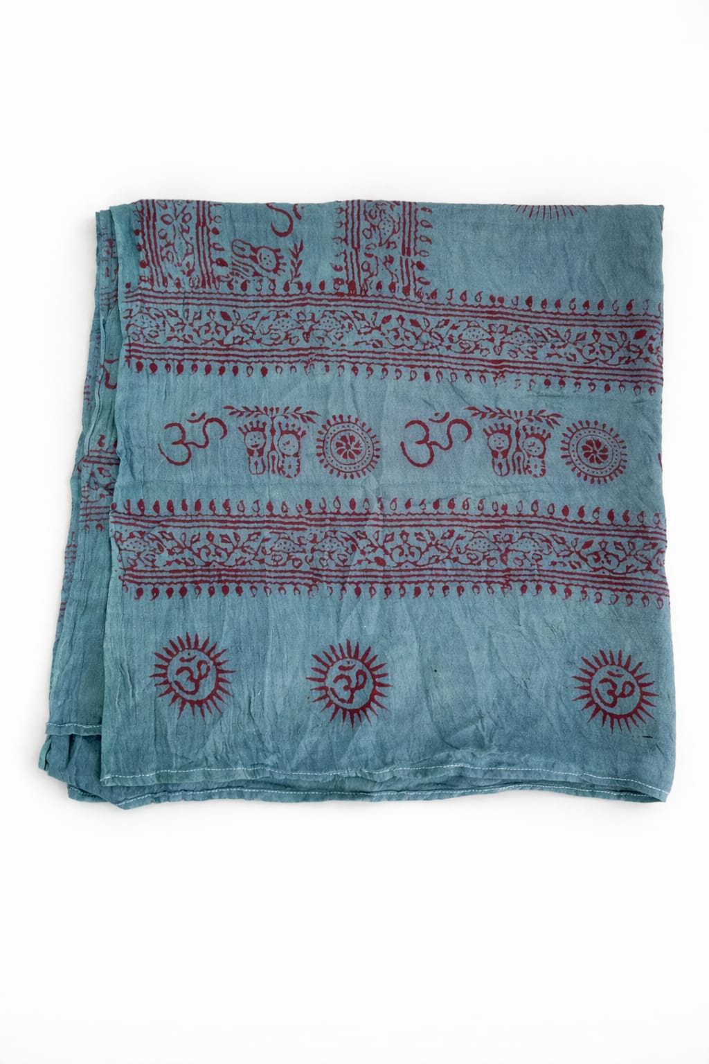 Experience the elegance of the Mantra Shawl—a folded, light blue luxurious viscose fabric adorned with red Hindu Om symbols, sun motifs, and intricate decorative patterns printed on a pristine white background. Ideal as a spiritual wrap or styled with your favorite bralette for a fashionable statement.