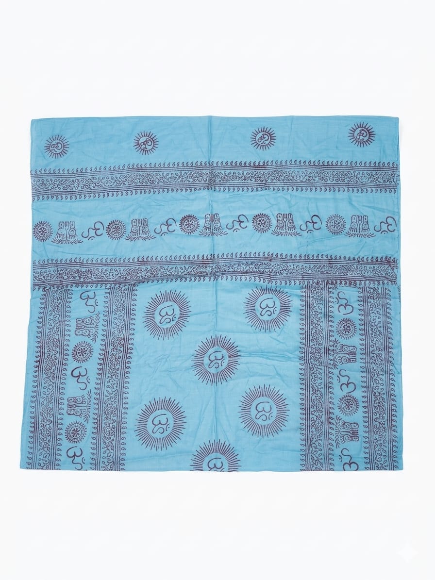 A light blue square Mantra Shawl made from luxurious viscose, adorned with intricate dark blue patterns, including sun-inspired motifs and decorative borders, is shown laid flat on a white background.