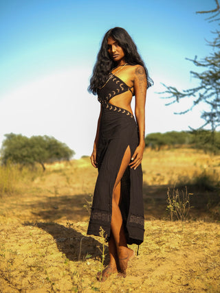 Backlit dusk shot of the Aadhya black block print cotton maxi dress with hand raised to her hair