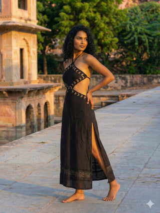 Aadhya black block print maxi dress walking through a palace courtyard with the side slit open