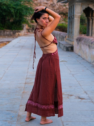 Aadhya maroon block print maxi dress with arms raised behind her head in a palace courtyard