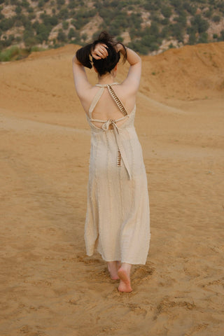 Aaven Crossback Dress in natural cream from the back, open crossback ties and patterned trim on show