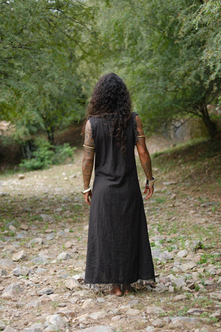Afra Maxi Dress black back view with fringe hem walking on rocky ground