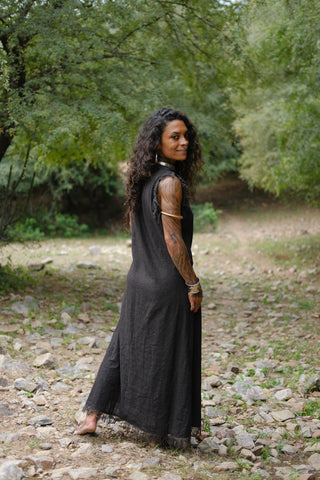 Afra Maxi Dress in black, three quarter pose with silver necklace by streamside trees