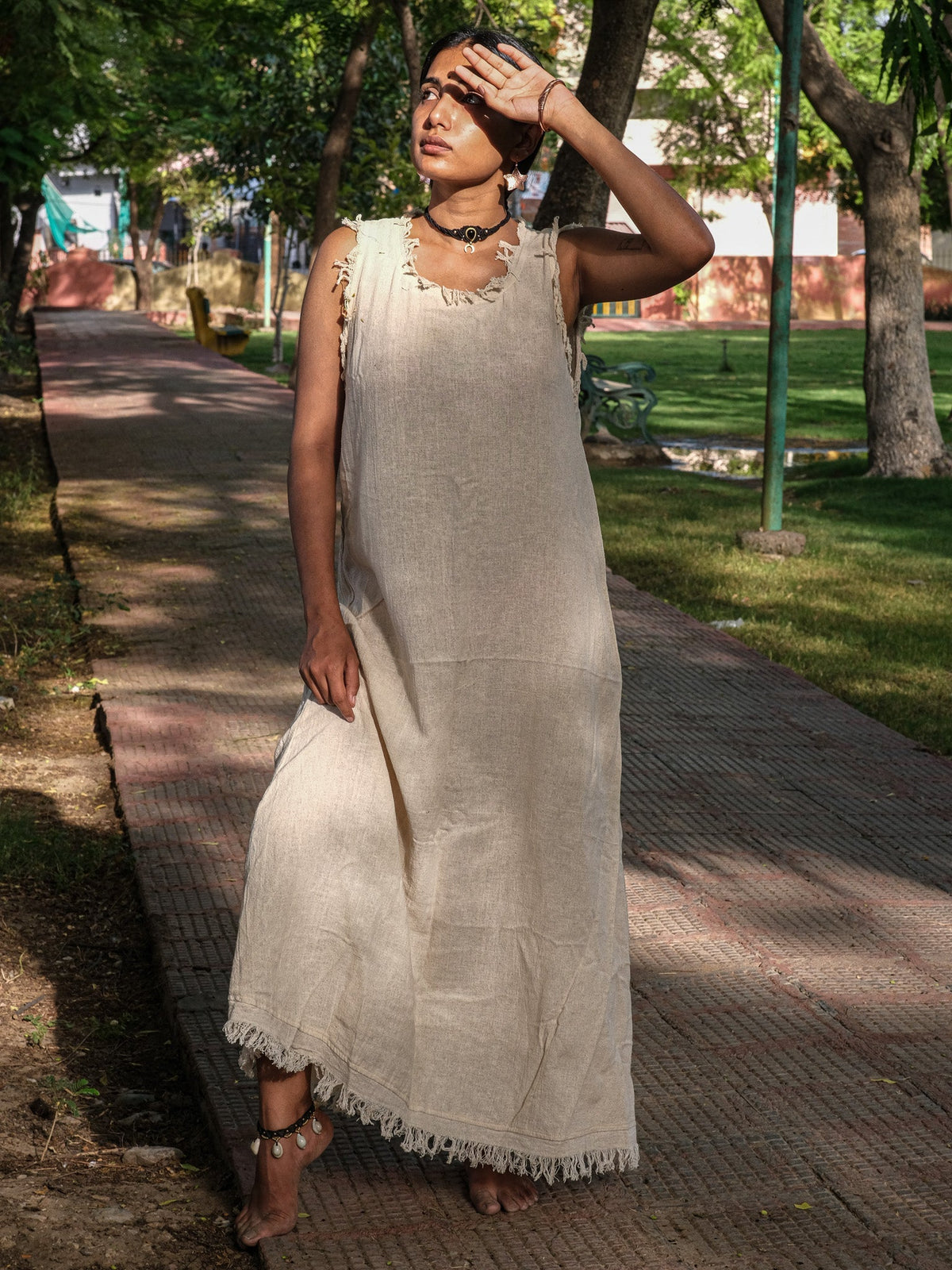 Afra Maxi Dress natural colourway with arms raised under forest canopy