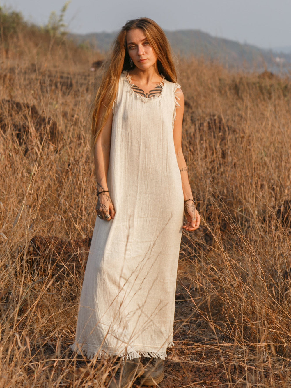 Afra Maxi Dress in natural cream cotton, full length front view in dry grassland