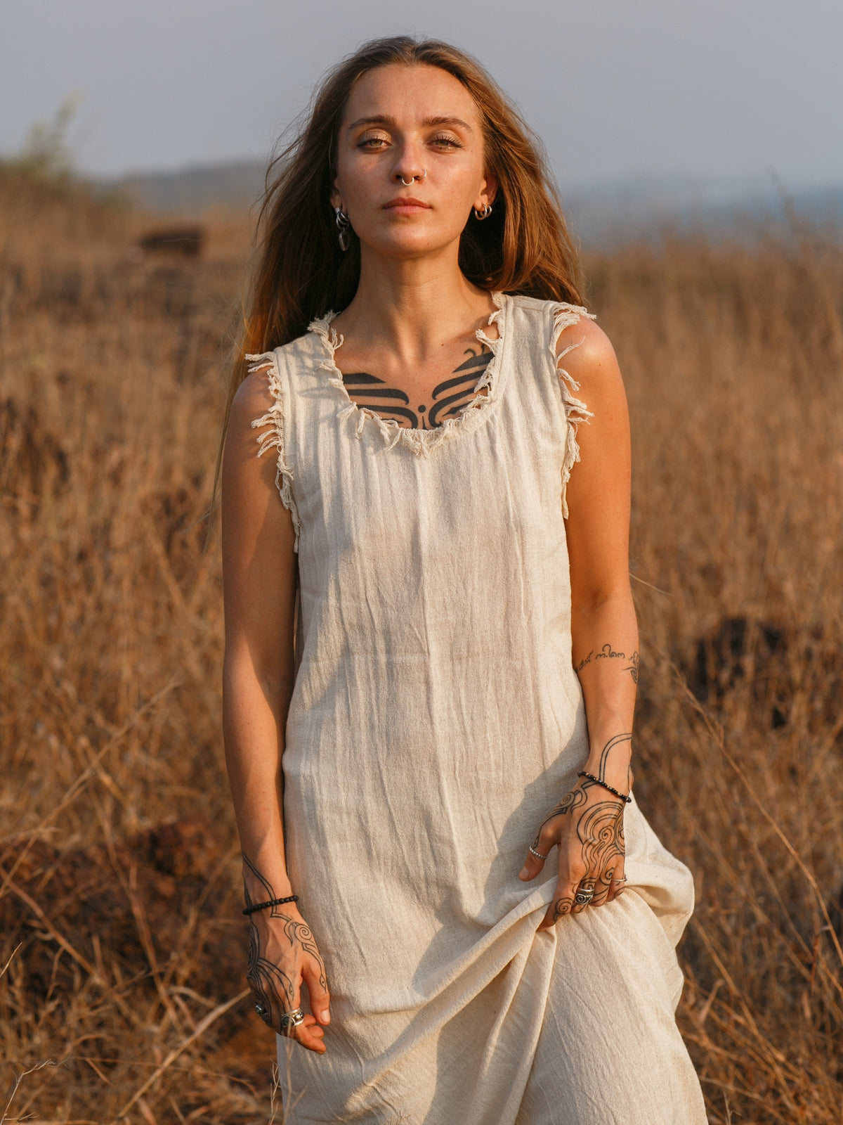 Afra Maxi Dress natural white with fringe neckline worn at golden hour in dry field