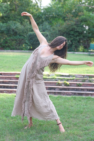 Alaya Dress natural fringe maxi, dancer pose with arm raised, garden lawn