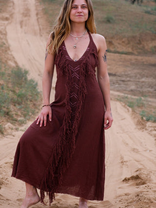 Alaya Dress wine-brown fringe maxi, model walking on sandy trail, front view