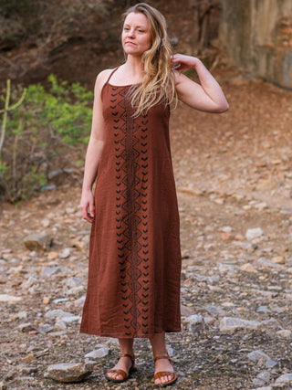 Model looking away with a hand through her hair, wearing the Anusrava brown block print cotton maxi dress at dusk