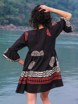 Back view of the Arva Short Dress showing the cream sunburst and red chevron print across the skirt