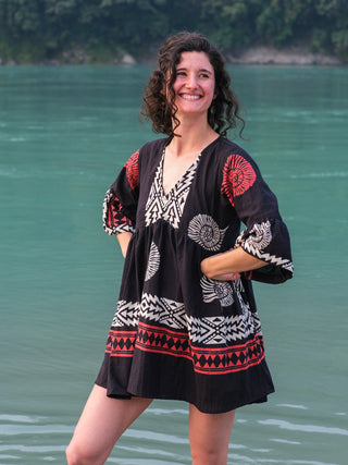 Model standing with hands on hips in the Arva black cotton boho mini dress, free-size flared fit