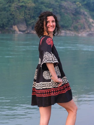 Side view of the black Arva Short Dress, cream and red geometric print and flared bell sleeves