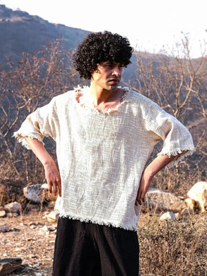 Natural cream baggy jute T-shirt worn hands on hips outdoors, open gauze weave and frayed hem, black pants