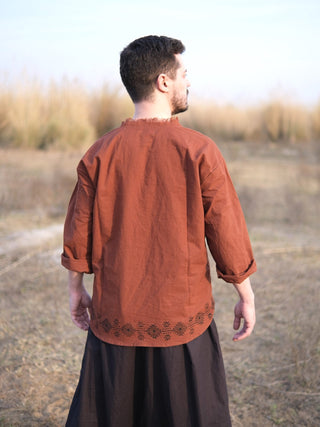 Rust baggy kurta from behind showing turned three quarter sleeve cuffs and printed hem