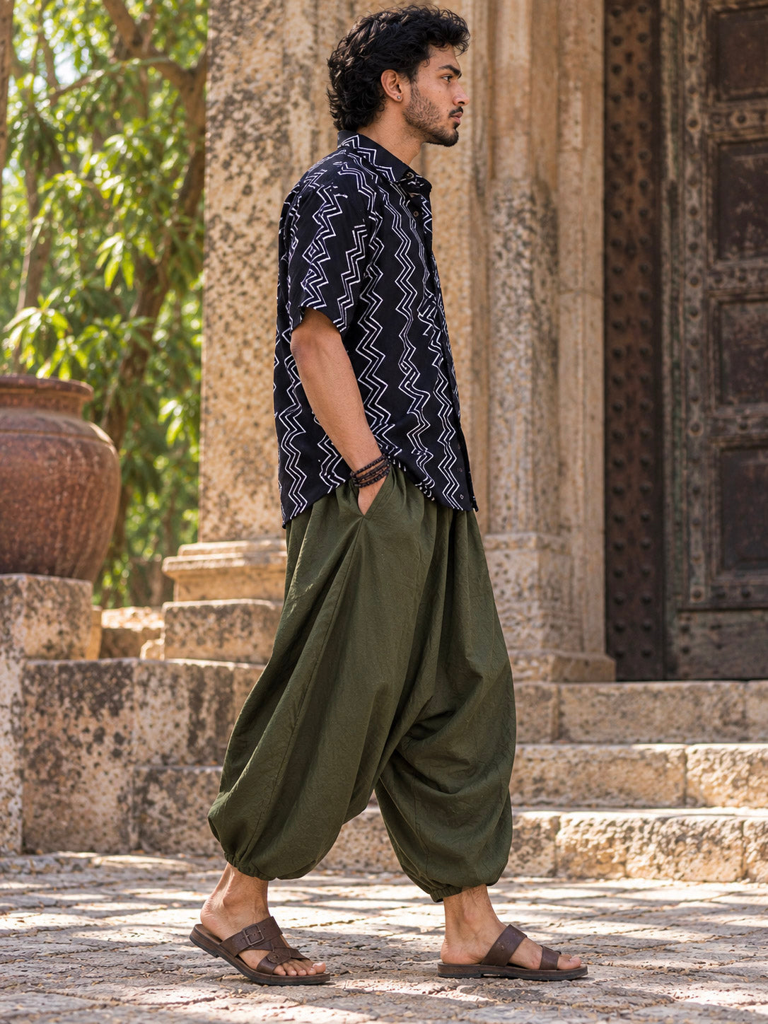 Side profile of the black printed baggy shirt for men, short sleeve ending above the elbow, street setting