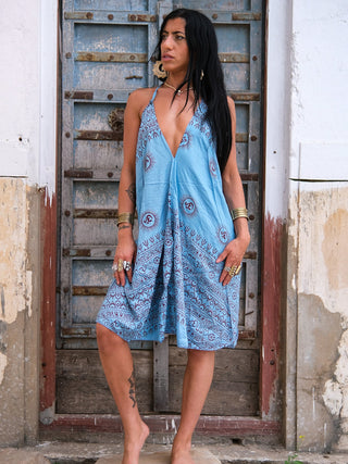 Sky blue halter dress with maroon Om print, worn against weathered blue doors
