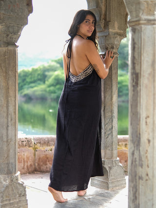 Black Devi Maxi Dress back view at lakeside stone archway