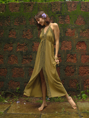 Olive green Devi Maxi Dress back view against mossy brick wall