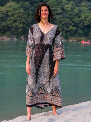 Dhaara Maxi Dress front view, deep V-neckline and feather print bodice against the turquoise river