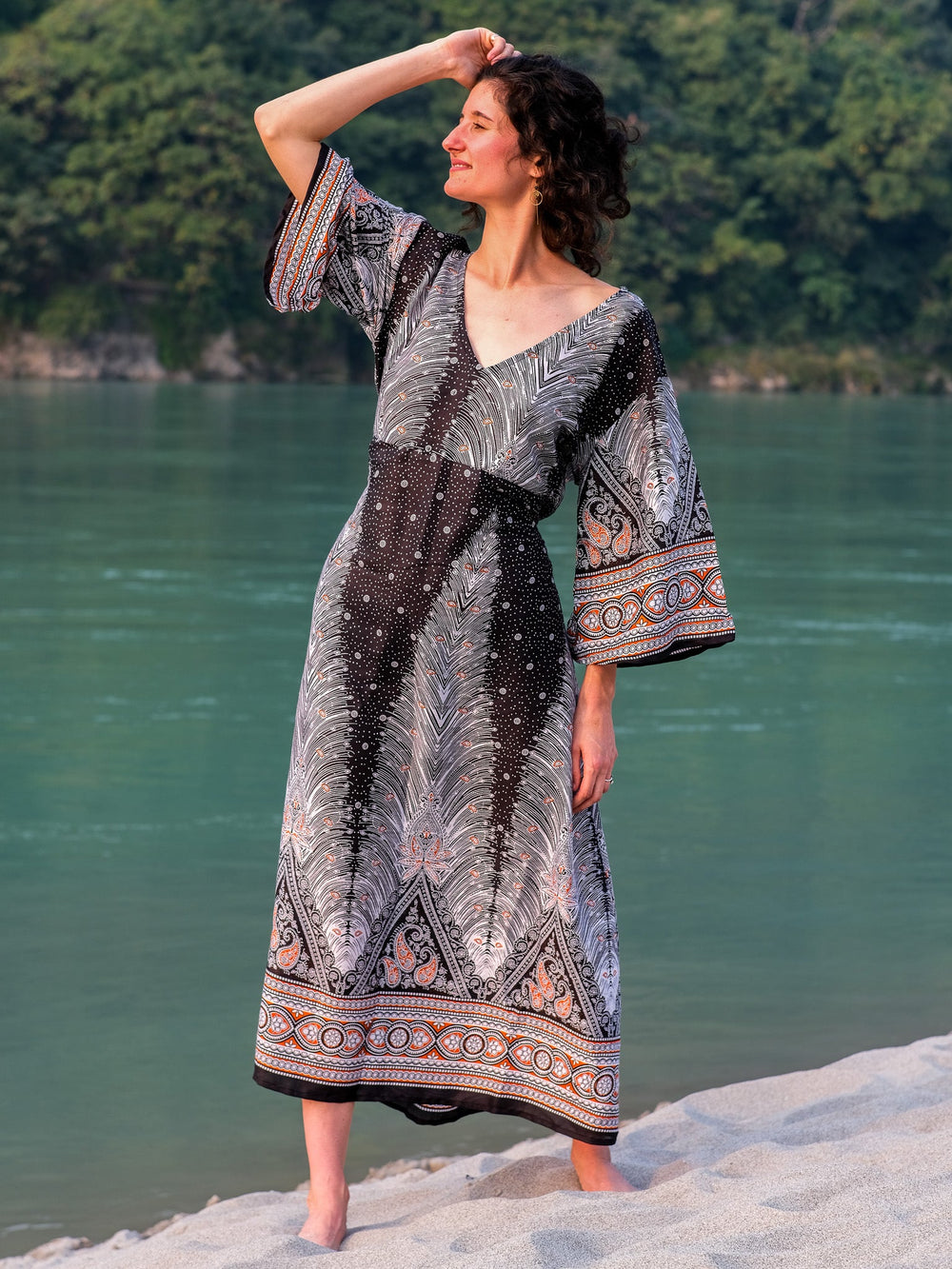 Dhaara Maxi Dress in black printed cotton, front view with flared sleeves raised and tie waist knotted