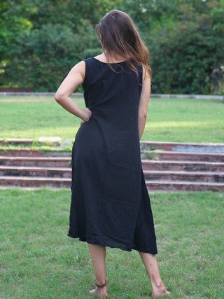 Ekakshi Maxi Dress in black cotton, back view on a lawn showing the smooth unprinted back
