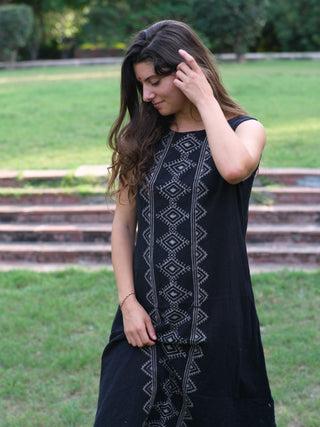 Ekakshi Maxi Dress in black cotton, sleeveless with a pale block print panel, model on a green lawn